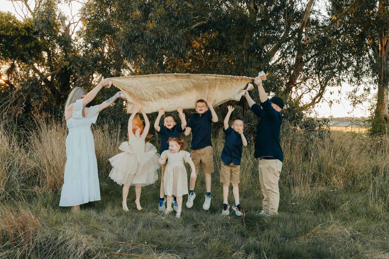Photographing my best friend. Family. mum and dad holding a blanket in the air above children. Children jumping underneath it.