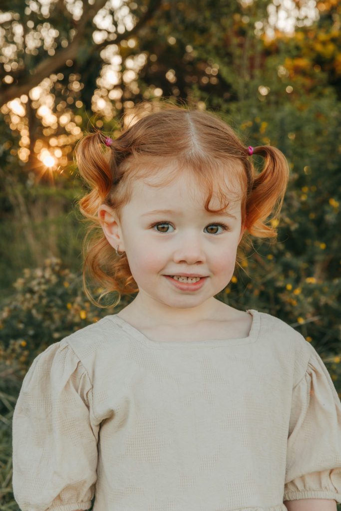 red hair. little girl. innocent smile at camera