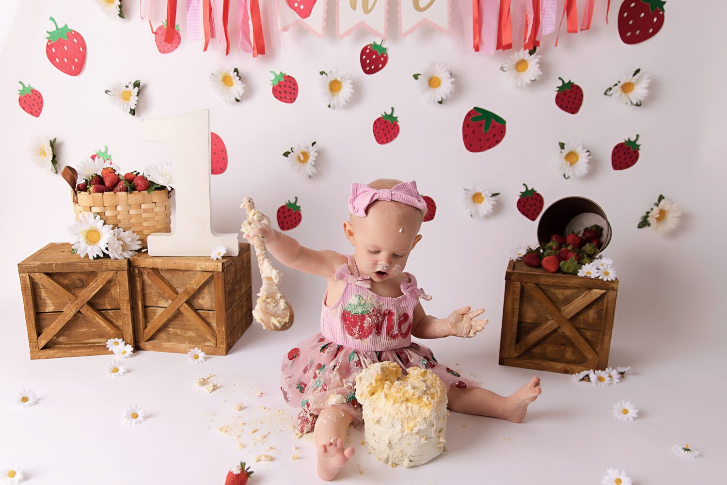 Strawberry and Daisy's on a white backdrop for a berry first birthday cake smash by Melbourne cake smash photographer Aurora Joy Photography