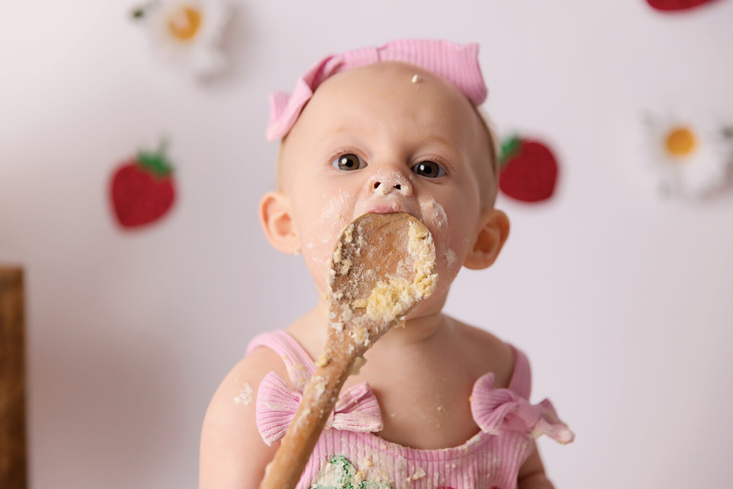 Strawberry and Daisy's on a white backdrop for a berry first birthday cake smash by Melbourne cake smash photographer Aurora Joy Photography