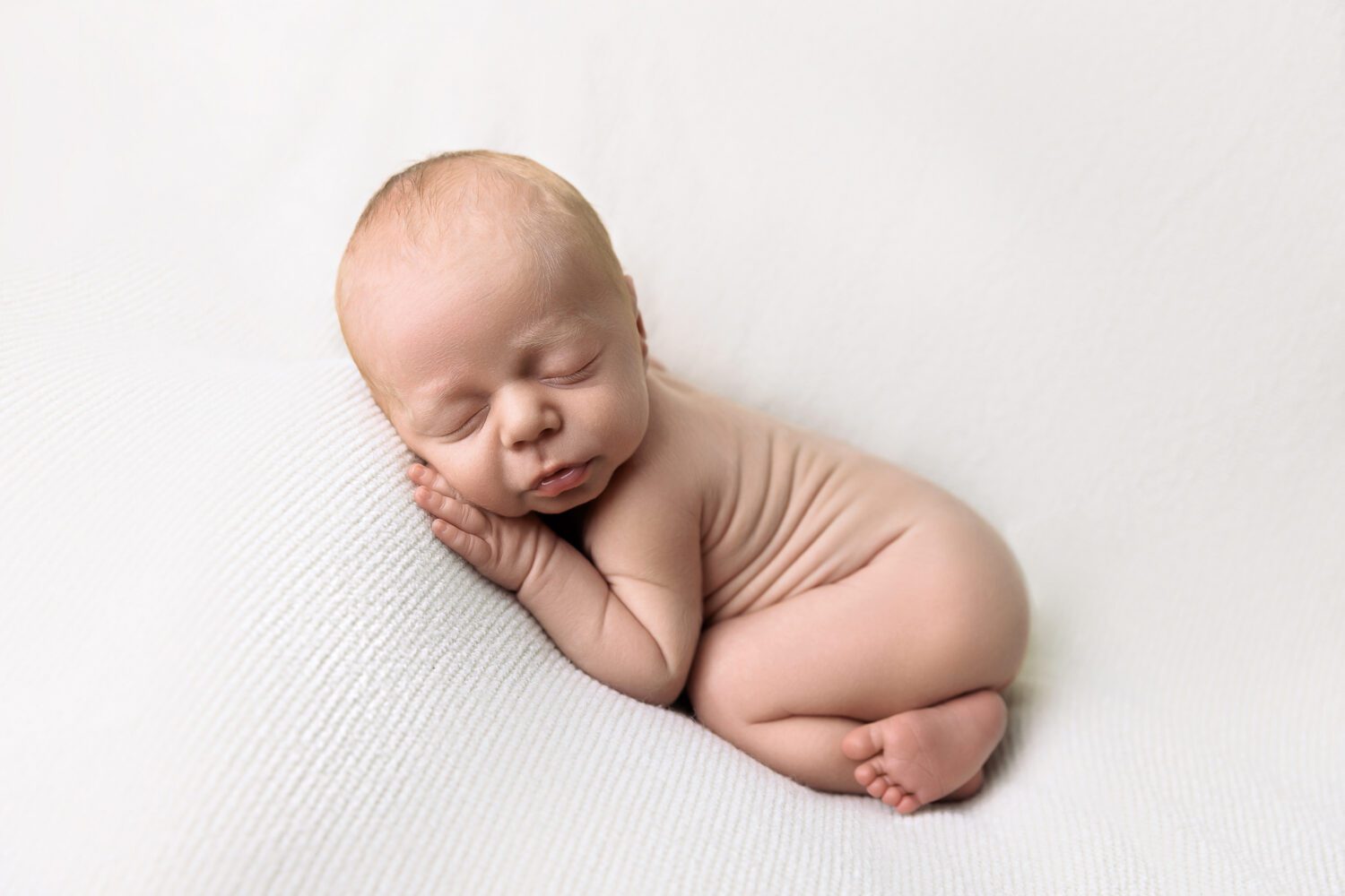 Peacefully sleeping newborn baby boy in a Bum up pose on a soft cream studio backdrop — newborn photography by Aurora Joy Photography, Stirling Western Australia