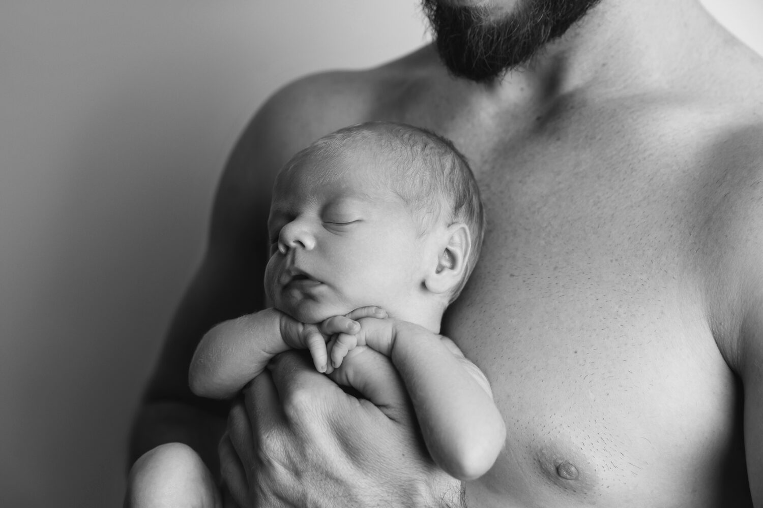 newborn photographer Perth Black and white intimate studio portrait of father with their newborn baby boy — newborn photography by Aurora Joy Photography, Stirling Western Australia