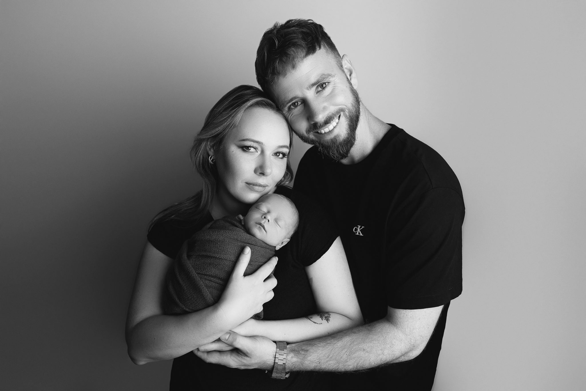 Black and white intimate studio portrait of both parents with their newborn baby boy — newborn photography by Aurora Joy Photography, Stirling Western Australia